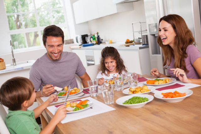 parent family-laughing-around-a-good-meal-in-kitchen
