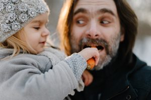 father-playing-with-his-baby-girl-on-winter-cold-sunset