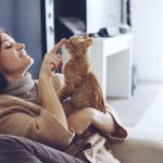 young-woman-wearing-warm-sweater-is-resting-with-a-cat