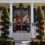toy soldier christmas decoration on front porch with topiearies