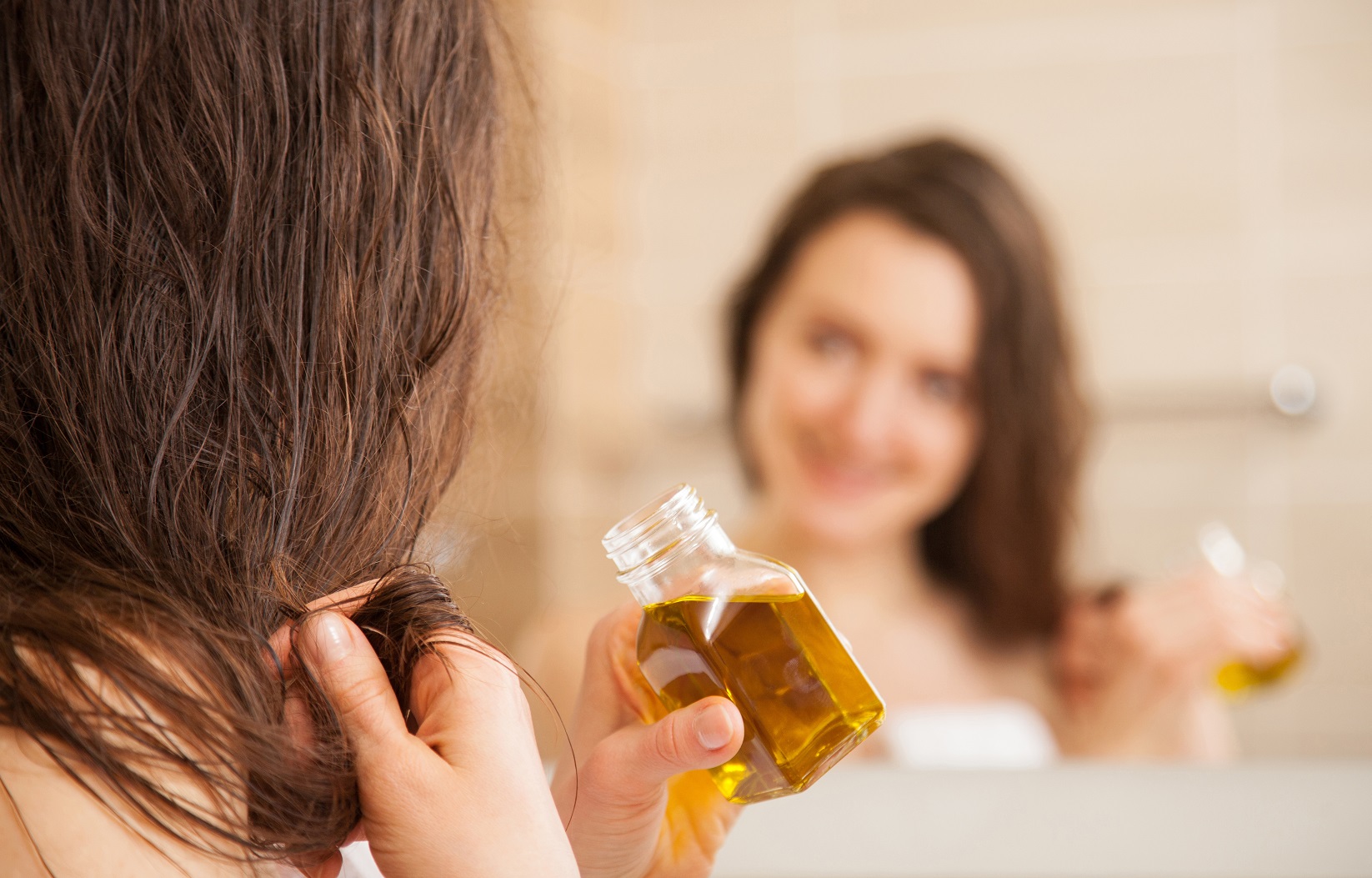 beauty woman applying oil mask to hair tips