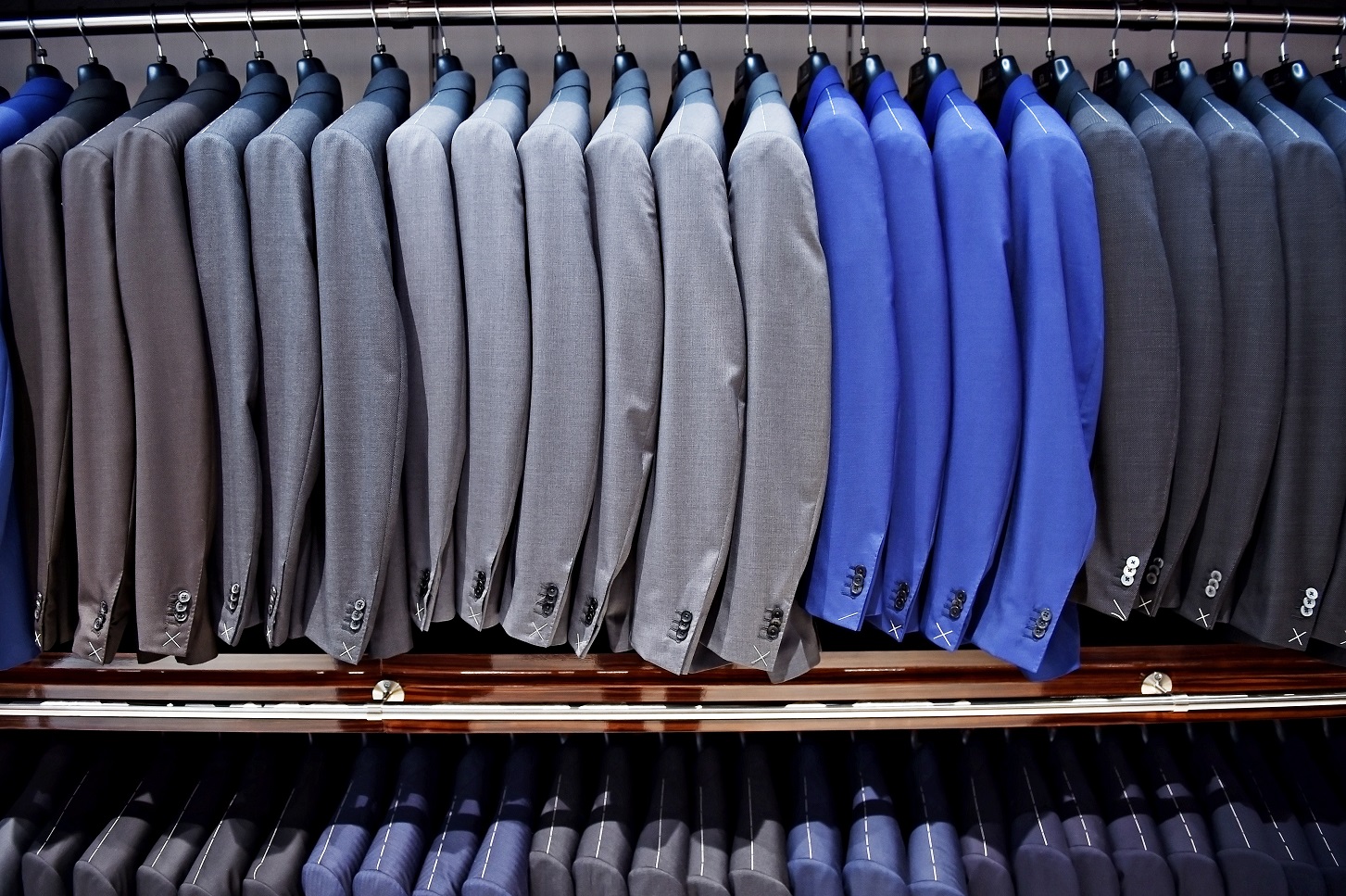 Elegant blue and gray suits on hangers