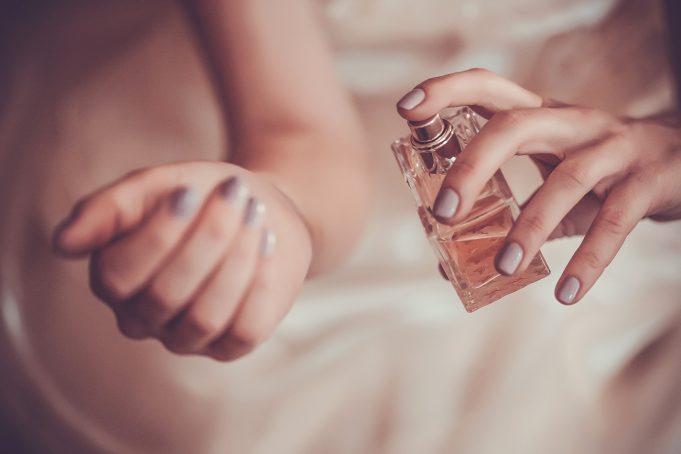 fragrance girl-applying-perfume-on-her-wrist-221862415