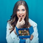 happy-woman-eating-chocolate-candy-portrait