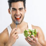 handsome-young-man-eating-healthy-salad-283224002